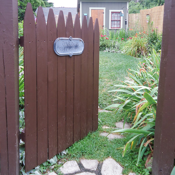 DIY garden gate opening into a backyard