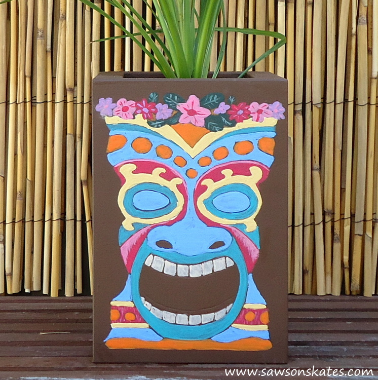 dLove this colorful DIY tiki planter! The plan is so easy to follow, it's made with scrap wood and the tiki faces were traced on the container, so painting them is nearly goof proof! Definitely making this!