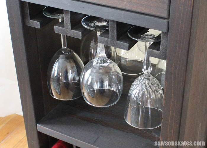 The DIY wine cabinet features three stemware holders that can hold up to 12 wine glasses.