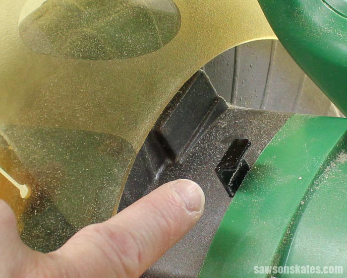 The second step to replacing a miter saw blade is to locate and press the spindle lock