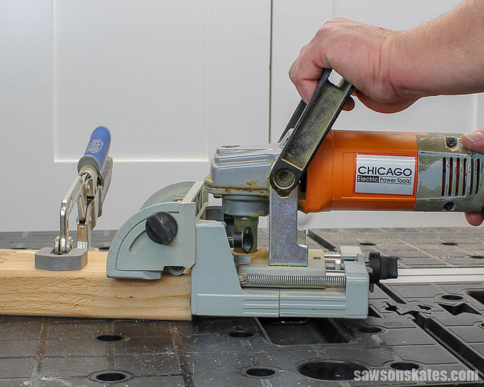 A biscuit joiner cutting a biscuit slot into the endgrain of a workpiece