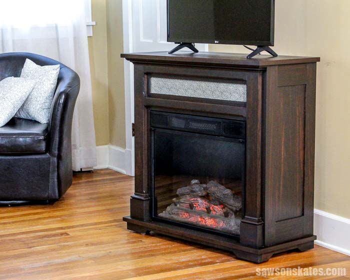 These free plans show how to make a DIY electric fireplace TV stand! Build a surround for your fireplace insert then sit beside a cozy faux fire and watch TV!