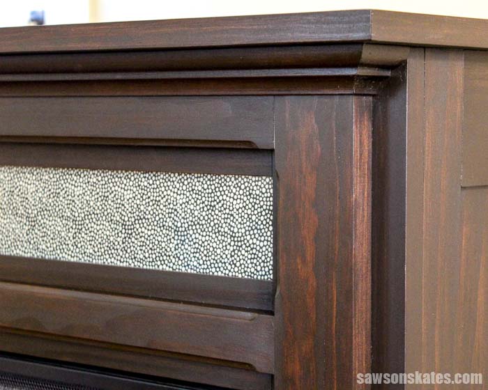 A piece of glass in this DIY electric fireplace mantel hides TV cable boxes