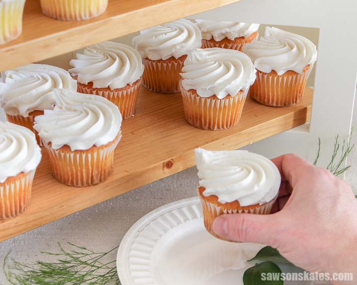 Removing a cupcake from a wooden DIY cupcake stand