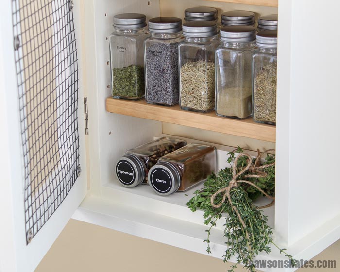 Herbs and spices organized in a wall-mounted DIY spice rack