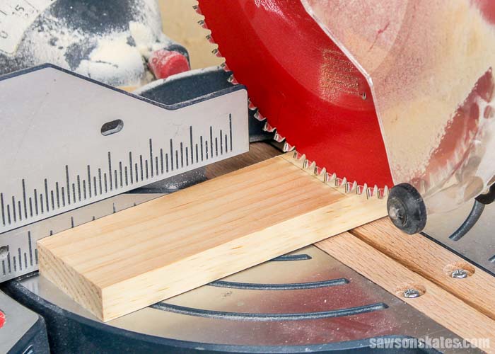 Positioning the blade of a miter saw to allow for kerf when cutting wood.