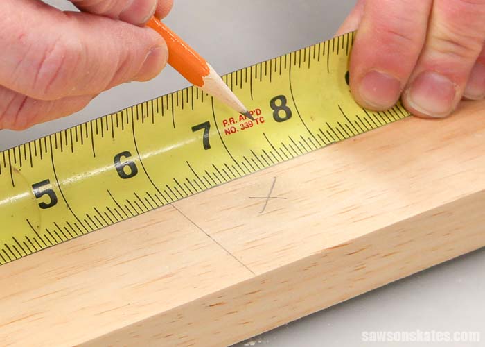 The first step to cutting wood is to measure and mark an "x" on the waste side