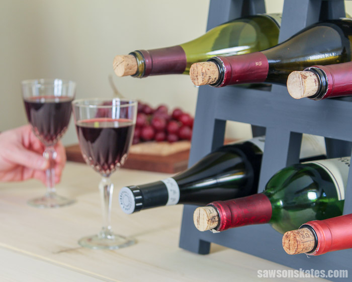 A do it yourself wine rack on a countertop with wine bottles and wine glasses
