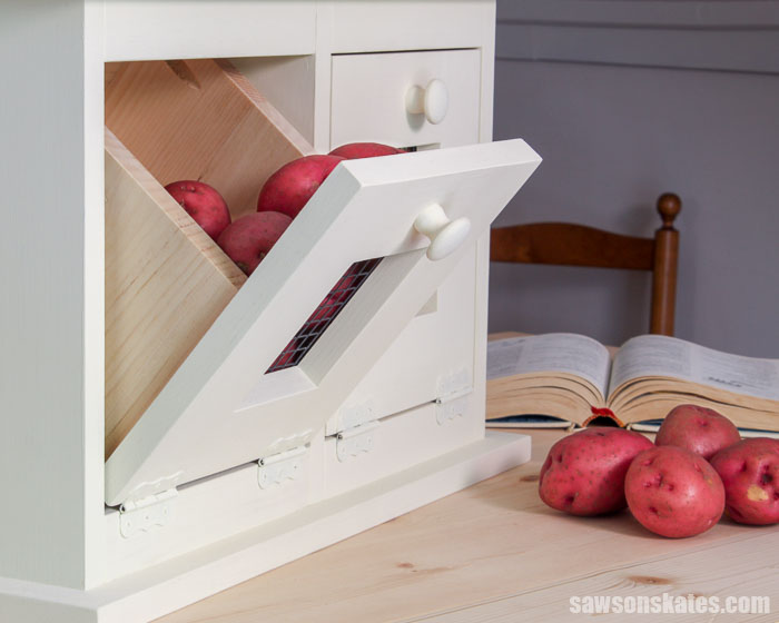 A farmhouse DIY vegetable storage bin with a tilt out drawer filled with potatoes