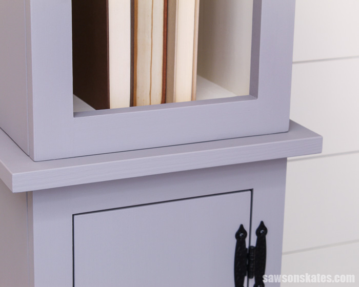 Narrow DIY chimney cupboard has a bookshelf on top and a door at the bottom