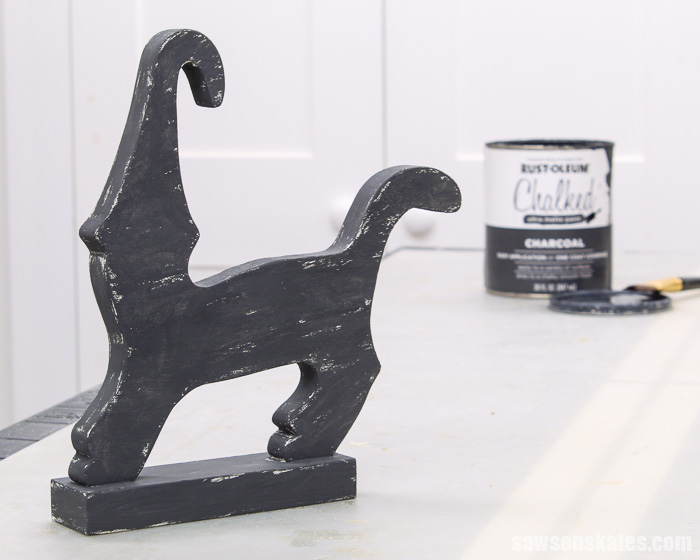 A DIY Halloween cat decoration painted black with a can of black chalk-type paint in the background