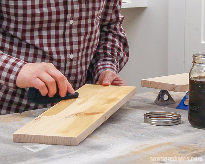 Applying a coffee wood stain to a piece of pine