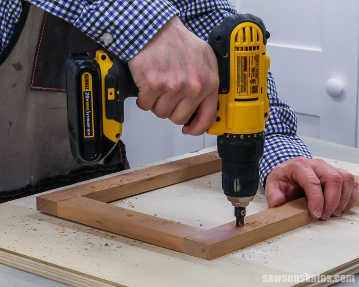 A drill making countersink holes in the glass holder for a tabletop DIY wood photo frame