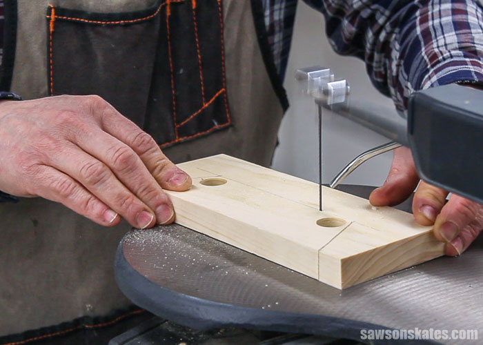 Using a scroll saw to cut the front leg detail of a DIY bedside table with drawers