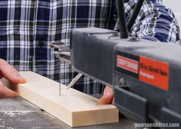 Using a scroll saw to cut out the curved rail detail of an antique-inspired DIY step stool