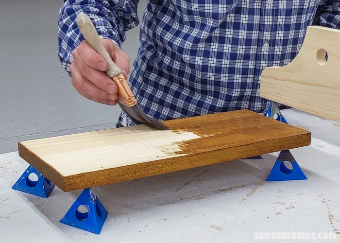 Using a brush to apply a stain and poly in one to the front side of a board