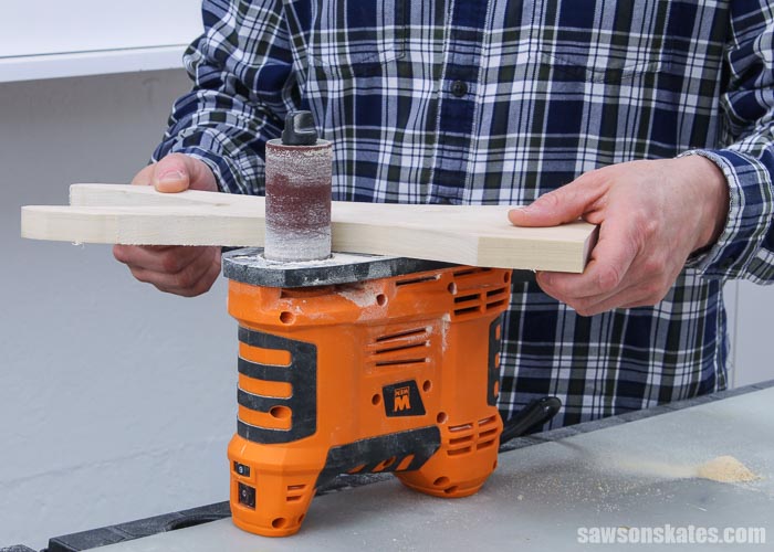 Using a spindle sander to smooth the edges of a wooden DIY boot puller