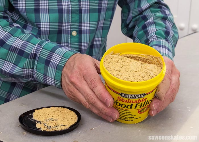 Holding a can of Minwax Stainable Wood Filler