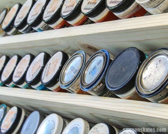 8 oz paint containers on a DIY wall-mounted paint display rack