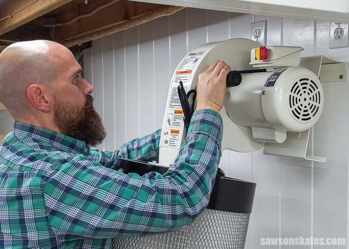 Attaching a wall-mounted dust collector to a bracket