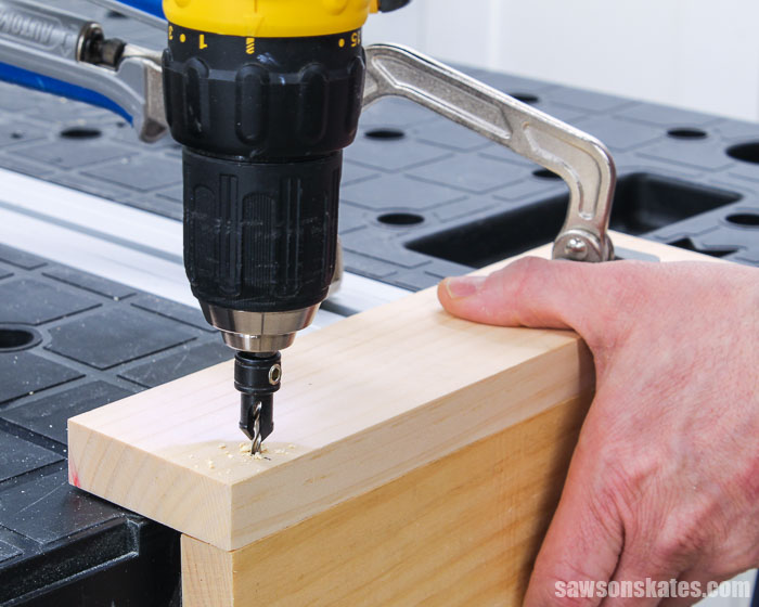 Using a drill and a countersink drill bit to make a countersink hole in a board