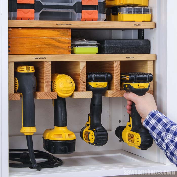 Hand putting a drill into drill storage rack