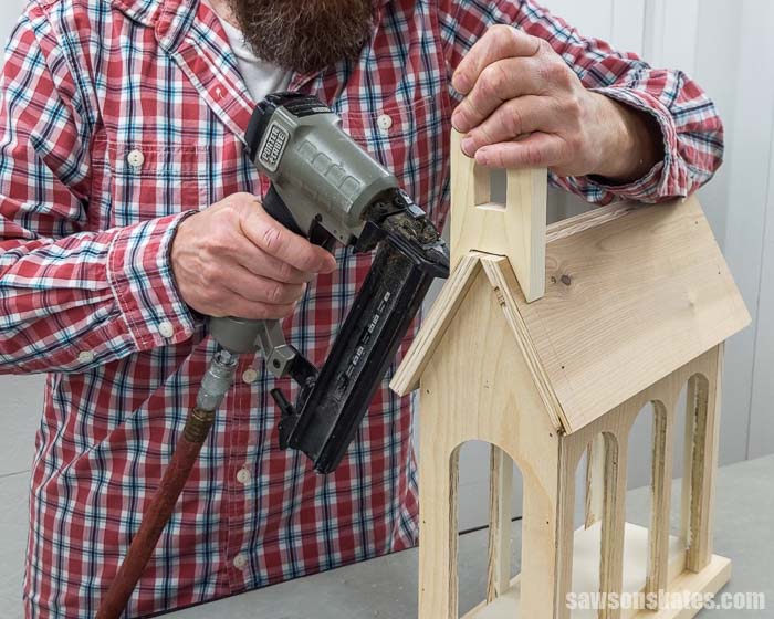Using a brad nailer to attach the steeple to a DIY holiday card holder