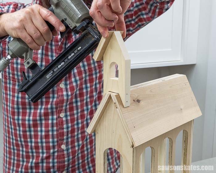 Using a brad nailer to attach the roof to the steeple for a DIY holiday card holder