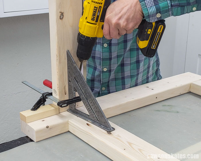Using a drill to attach a side rail to a leg assembly for a DIY drill press stand