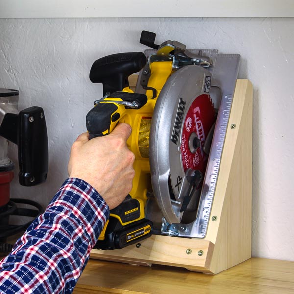 Hand placing a circular saw into a DIY holder