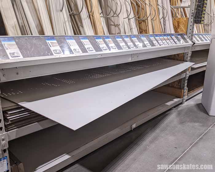 Hardboard on a shelf at a home improvement store used to line the inside of a DIY miter saw dust hood