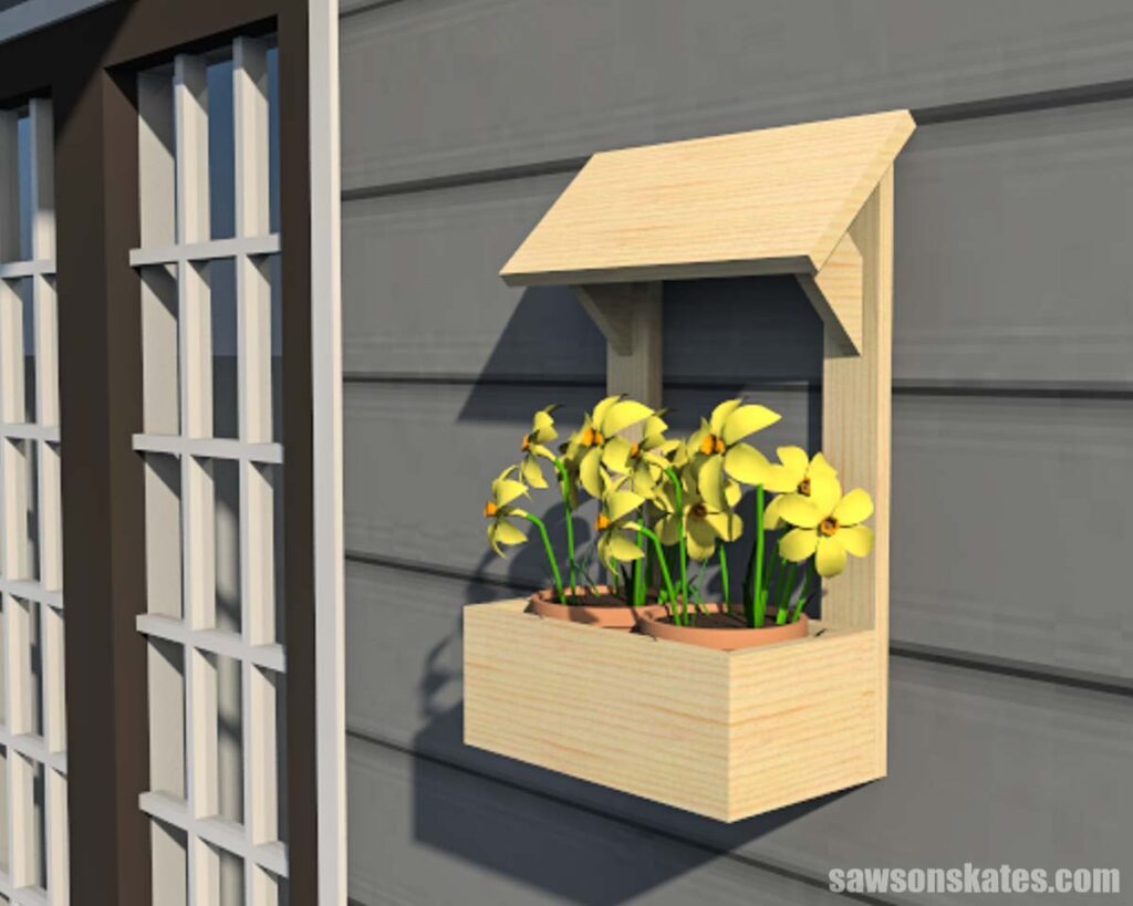 DIY outdoor wall-mounted planter on the side of a house with yellow flowers