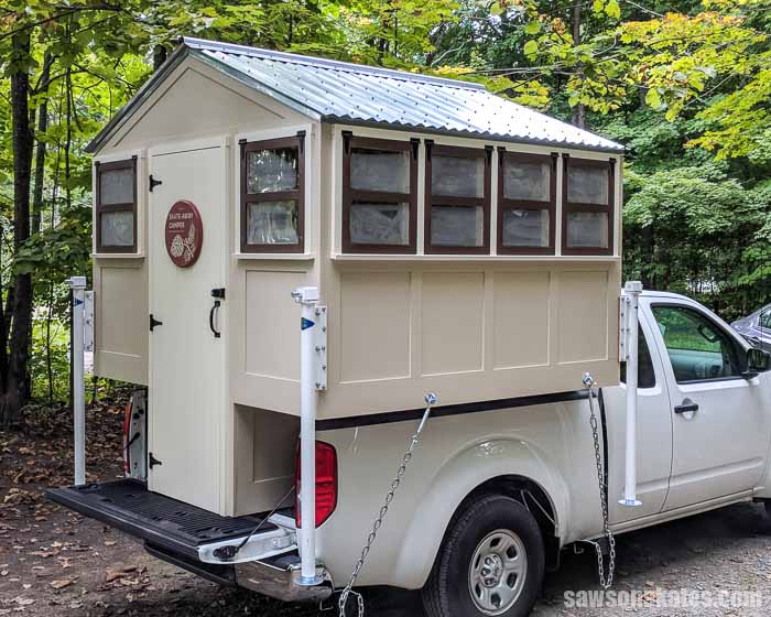 DIY truck camper shaped like a tiny house on the back of a pickup