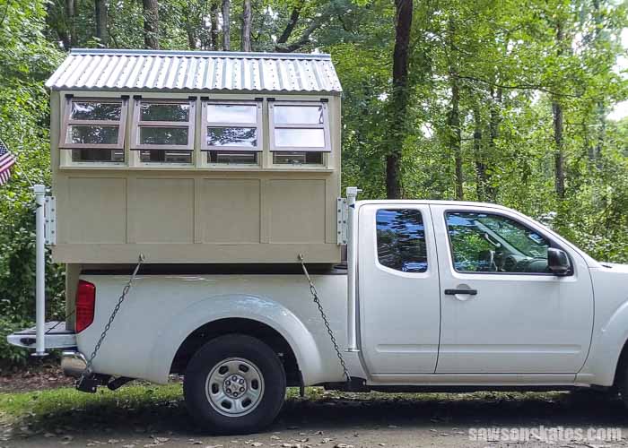 Side view of a DIY truck camper in the bed of a pickup truck
