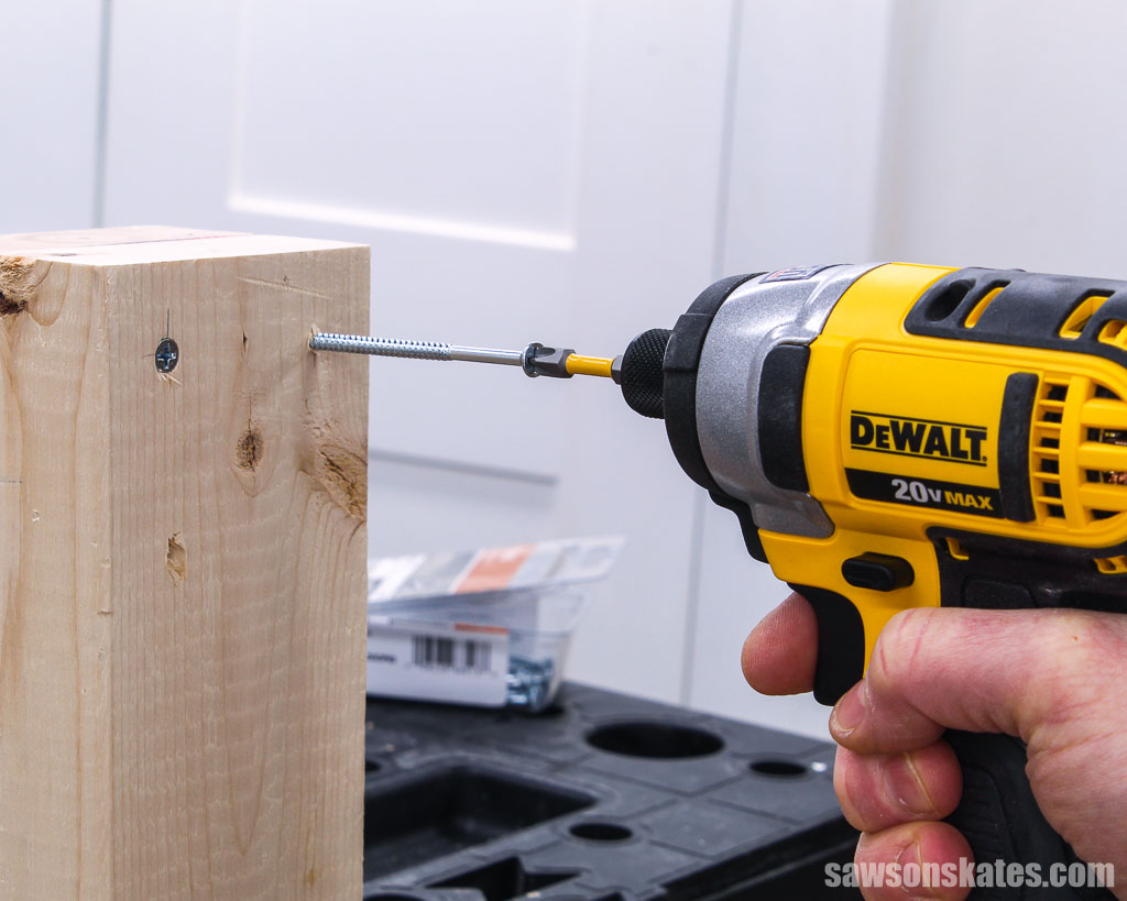 Using an impact driver to drive a screw into wood