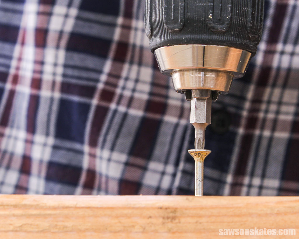 Drill driving a screw into a piece of wood