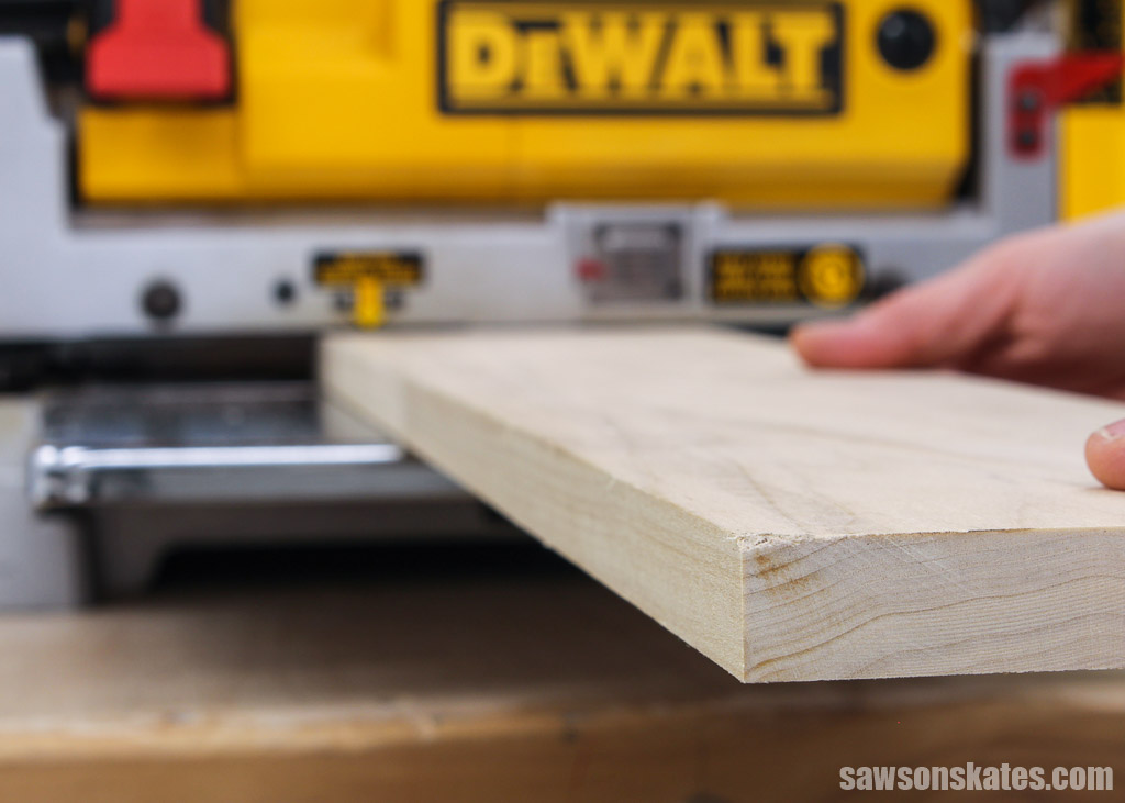 Close up of the end of a board going through a planer