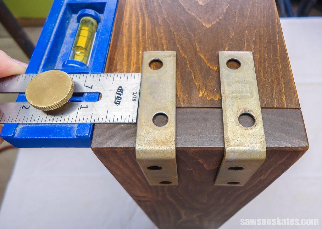 Positioning the metal brackets on a DIY bar cart tray