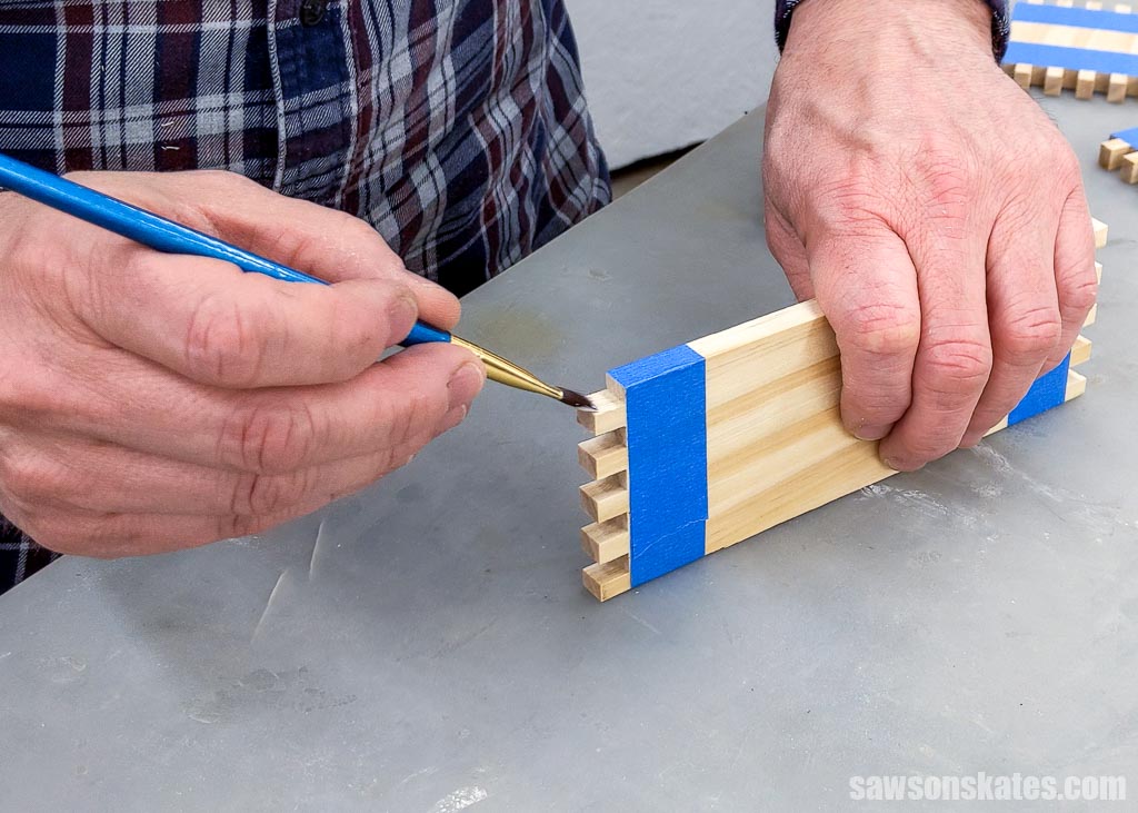 Using a paintbrush to apply glue to a box joint