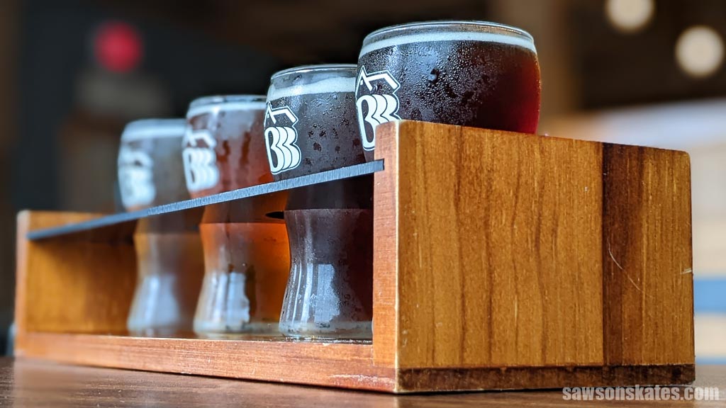 Four small beer glasses in a beer serving tray made with scrap wood