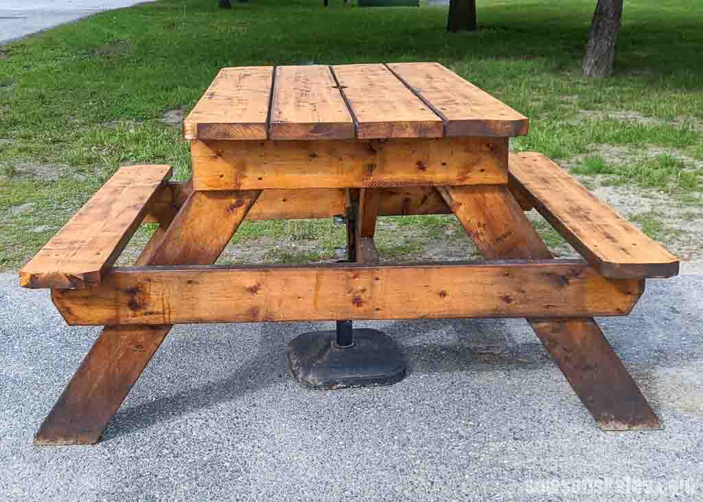 Side view of a small DIY picnic table with grass in the background