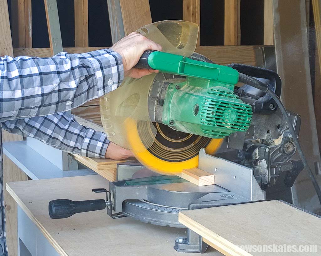 Using a miter saw to cut a piece of wood