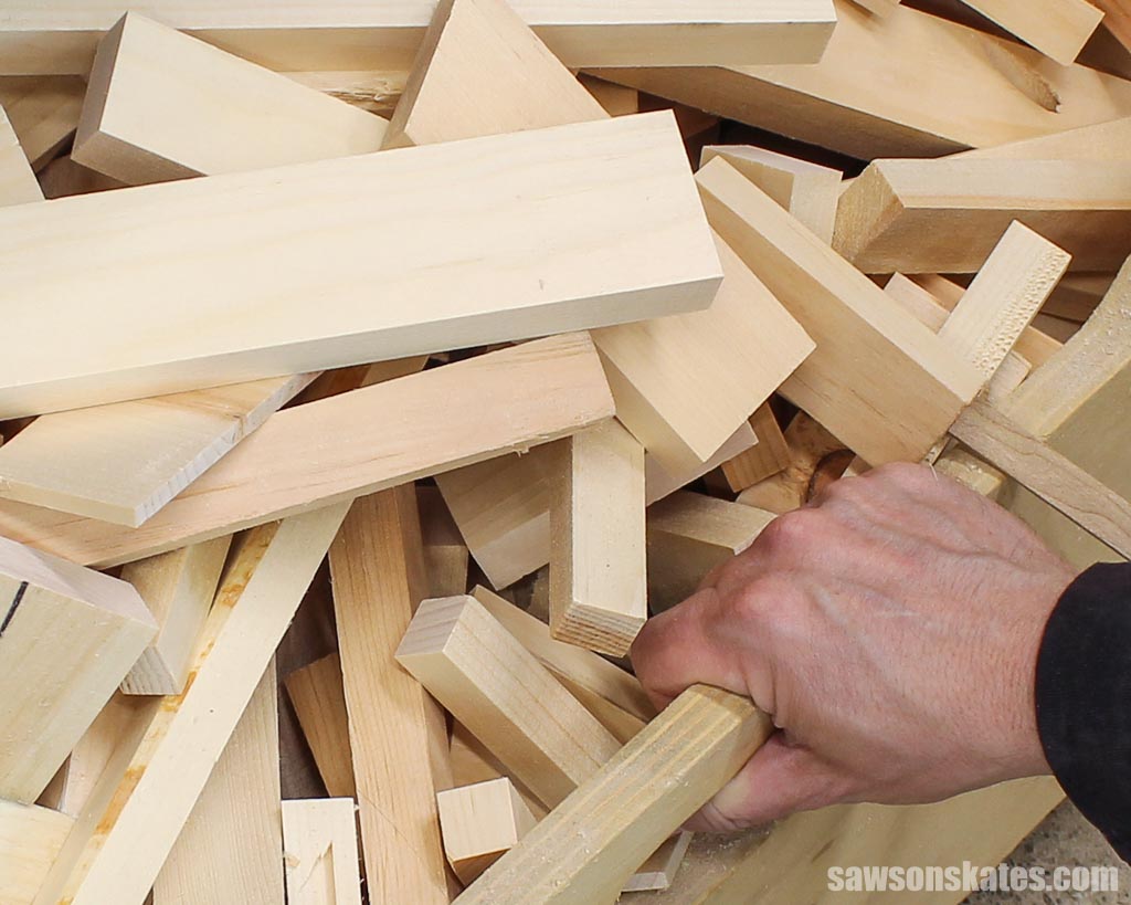 Hand reaching into a pile of scrap wood