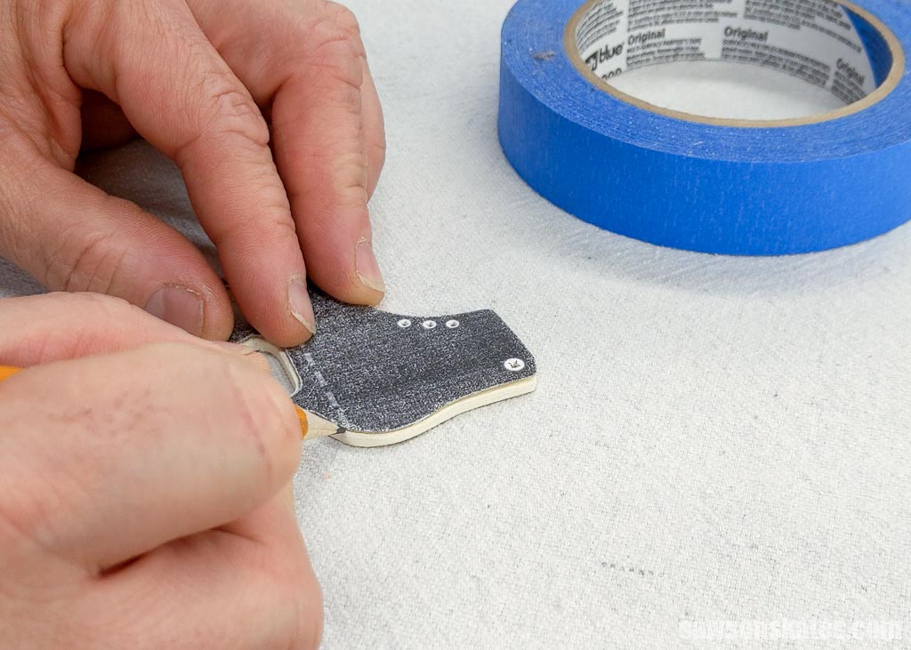 Marking the location to paint the blade on a wood DIY ice skate Christmas ornament