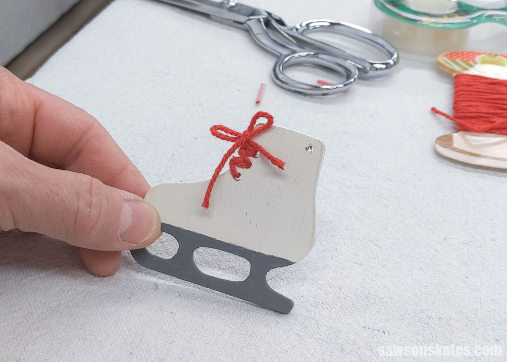 Tying a bow in the shoelaces for a DIY ice skate Christmas ornament