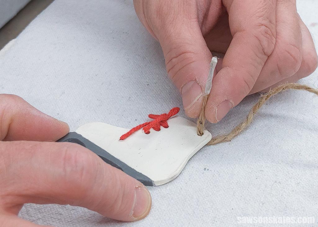 Threading a piece of jute twine as a hanger for a DIY ice skate Christmas ornament