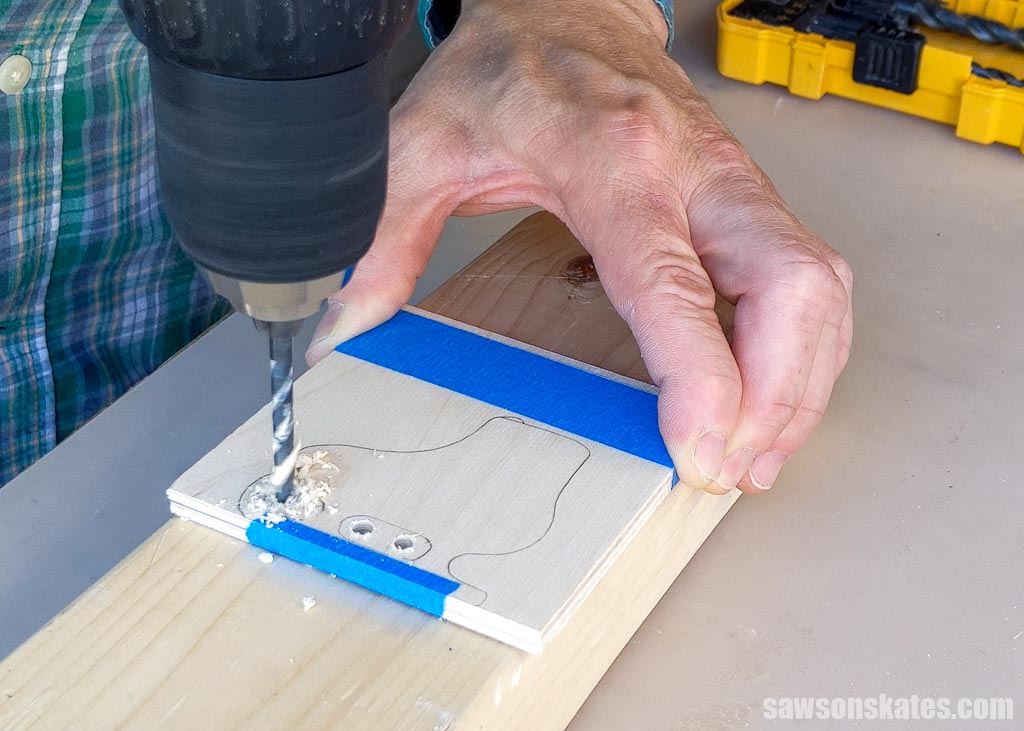Using a drill to bore holes in the areas between the posts on a DIY ice skate ornament