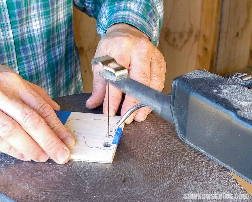 Using a scroll saw to cut out the areas between the posts on a DIY ice skate ornament
