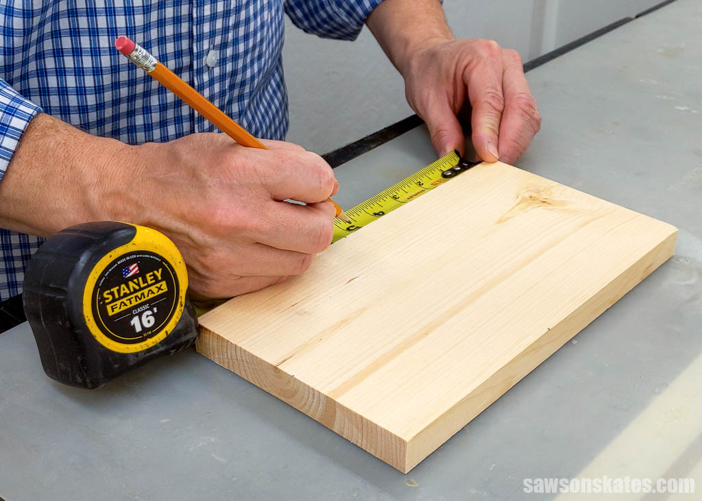 Using a pencil to mark the roof area for a DIY license plate birdhouse