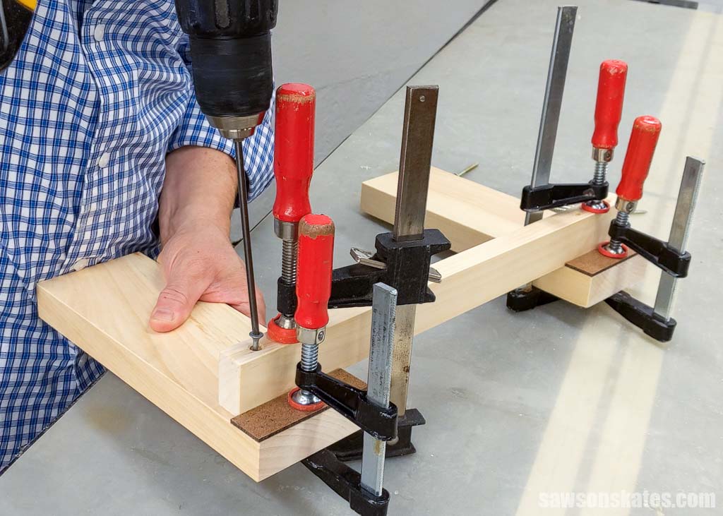 Drill driving a screw into the front stretcher of a DIY boot rack